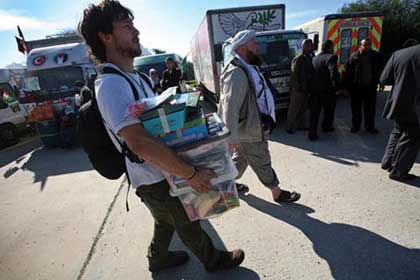 Members of the Viva Palestina aid convoy carry goods into Gaza.
